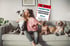 Frau umarmt zwei Hunde auf einem Sofa, ein dritter Hund liegt daneben. Magazin-Cover: "FAIRSTER TIERKRANKENVERSICHERER Allianz".