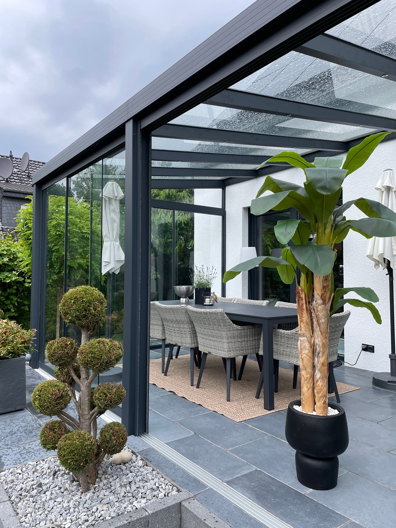 Terrassenüberdachung aus Glas mit Essgruppe