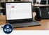 Laptop auf einem Schreibtisch zeigt ein Software-Dashboard mit Kontaktdaten neben einem schwarzen Bürotelefon - Software für Alarmierung - Notfall- und Krisenmanager (NKM®).