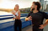 Healthy smiling couple jogging on bridge at sunset