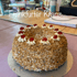 Frankfurter Kranz mit Nüssen und Kirschen auf einer silbernen Tortenplatte.