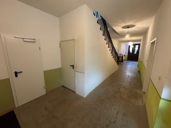 Flur mit mehreren Türen und Treppenaufgang im Hintergrund