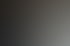 Zwei Personen arbeiten an einem Laptop mit Code auf dem Bildschirm, eine dritte Person schreibt in ein Notizbuch.