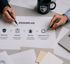 Zwei Personen zeigen auf ein Papier mit einem Krisenplan zu Prävention, Vorsorge, Reaktion und Wiederherstellung - Software-KRITIS Notfall- und Krisenmanager (NKM®).