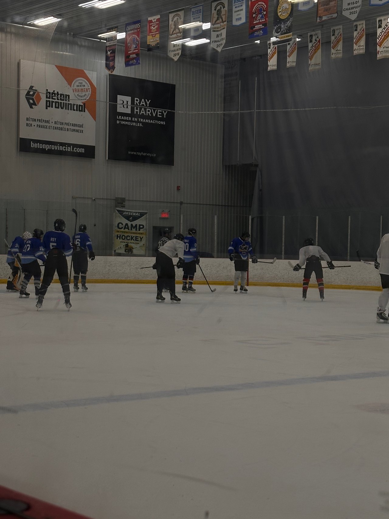 Des joueurs de hockey répartis sur la patinoire pendant une séquence de jeu