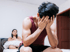 Man hides his face in frustration because of Low testosterone with his partner nearby.