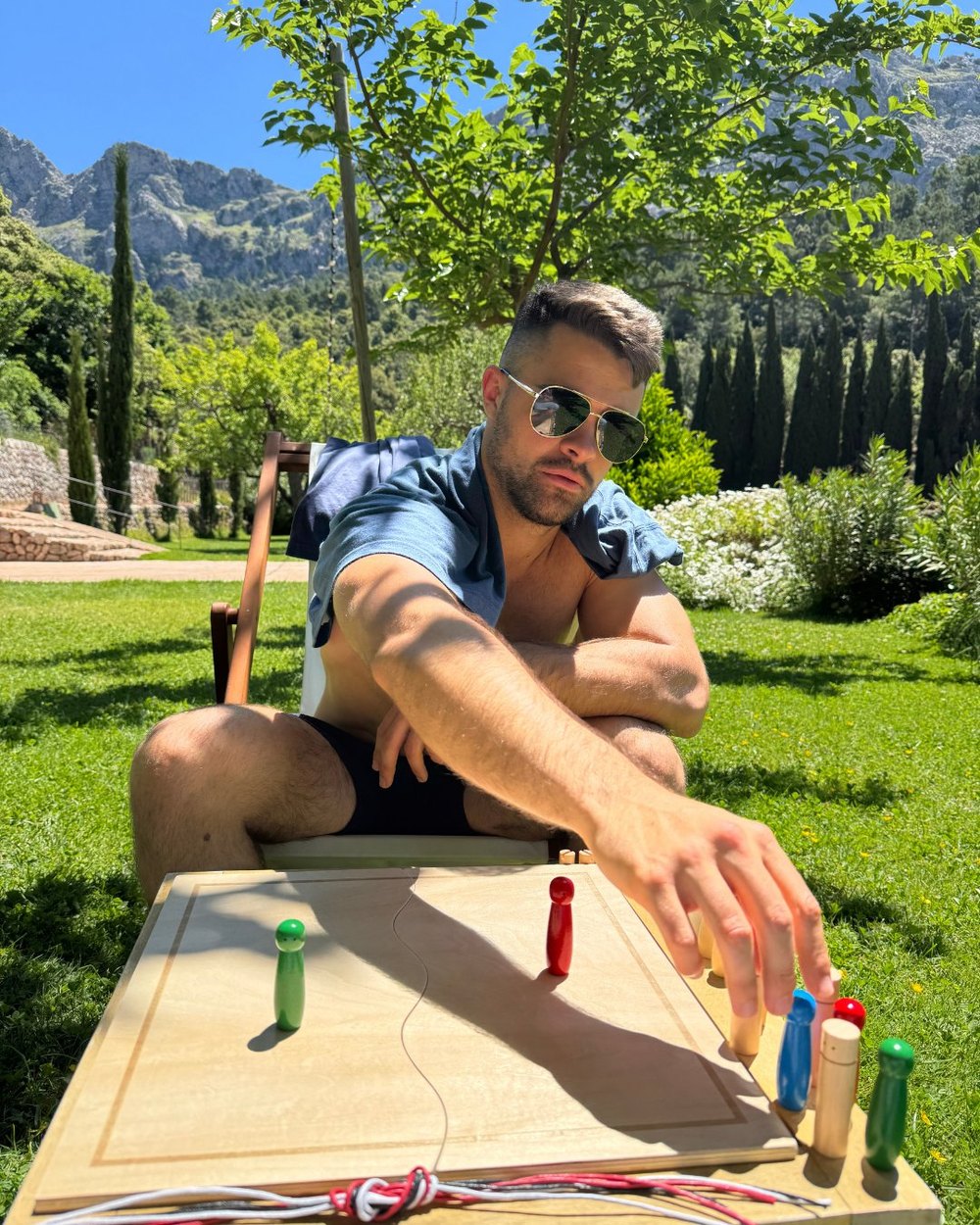 Mann spielt im Garten ein Brettspiel