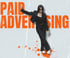 Woman in black suit and sunglasses posing with "PAID ADVERTISING" text in orange above her, orange splatters below.