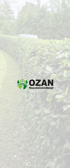 Ozan Hausmeisterdienst Logo auf einem Hintergrund aus grünen Bäumen und Büschen.