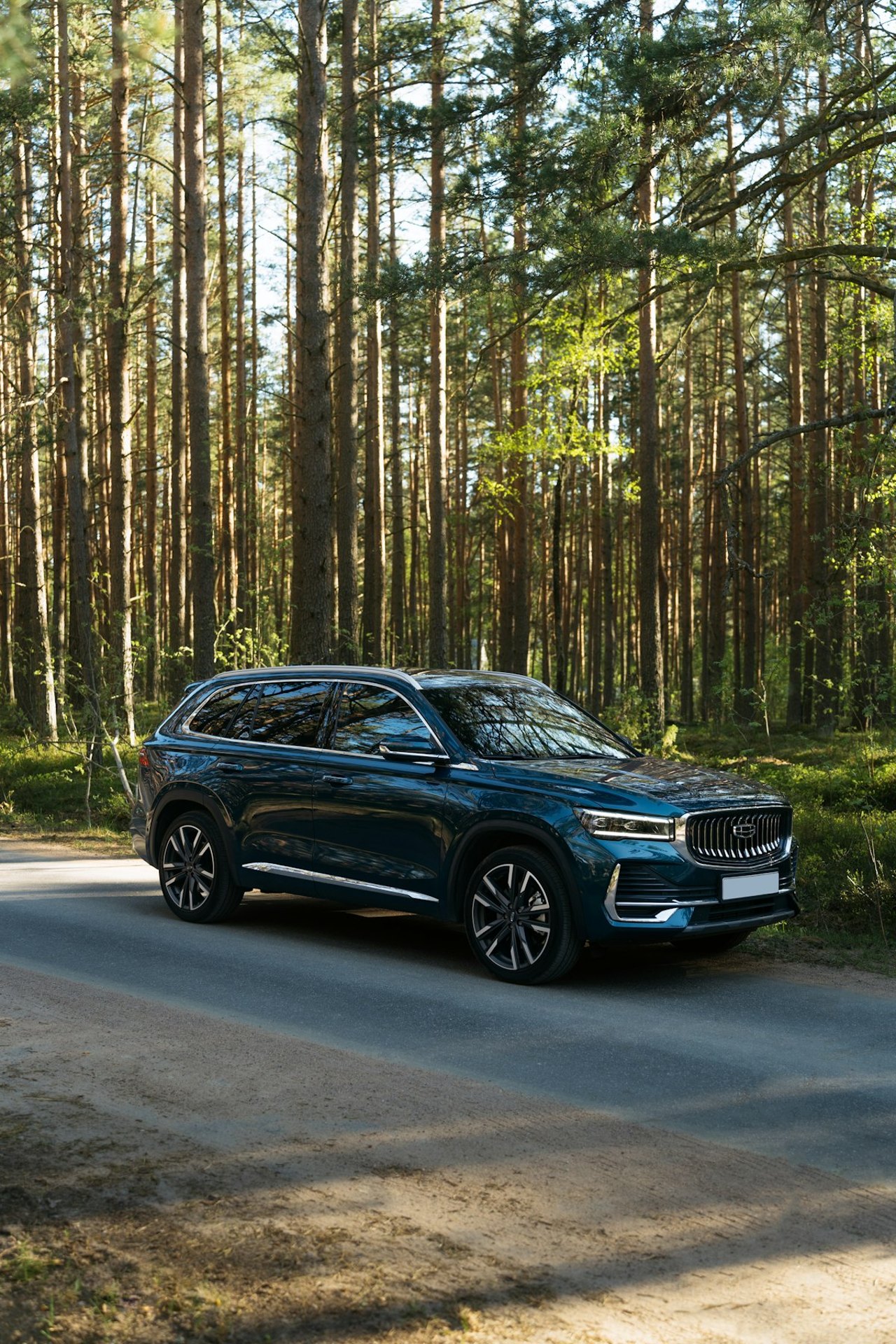 Blaues SUV auf einem Waldweg