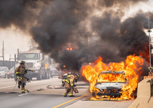 Firefighters putting out a car fire on a highway, the response a vehicle fire in Corona, California brings out.