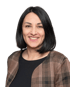 Eine lächelnde Frau mit dunklem, schulterlangem Haar und einer karierten Jacke.