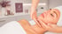 Eine Frau erhält eine Microneedling-Behandlung im Gesicht, die von Händen in weißen Handschuhen durchgeführt wird.