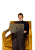 Ein junger Mann im Rollkragenpullover sitzt in einem gelben Sessel und arbeitet an einem Laptop.
