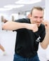 Filip - Boxtrainer BACKYARD Wien - Trainer schlägt einen Haken und lächelt dabei in die Kamera
