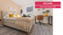 Eingerichtetes Schlafzimmer mit hellem Bett, gelben Kissen, Schreibtisch und Bürostuhl. Text: NACHHER Wohnung eingerichtet.
