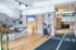 Fitnessstudio mit Holzboden, Laufband, Sprossenwand und Küchenzeile.