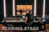 Oliver Wiesmann im Tonstudio Klangfabrik vor einem großen Mischpult mit Bildschirmen und der Aufschrift „SCORING STAGE“.