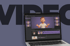 Videobearbeitungssoftware auf einem Laptop mit einem 3D-animierten Mann, der gestikuliert, vor dem Wort "VIDEO".
