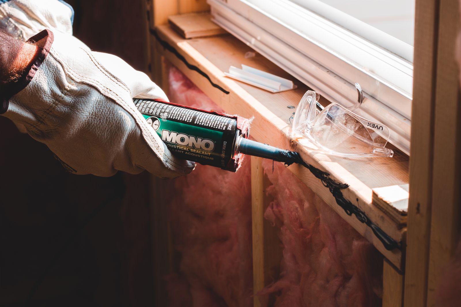 Installer sealing the exterior seam on a retrofit window replacement in a Sunnyvale home