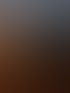 Gruppe junger Leute sitzt um ein Lagerfeuer vor schneebedeckten Bergen in der Dämmerung.