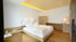 Helles Hotelzimmer mit Holzboden, Doppelbett, Nachttischen, Schreibtisch und Schrank.