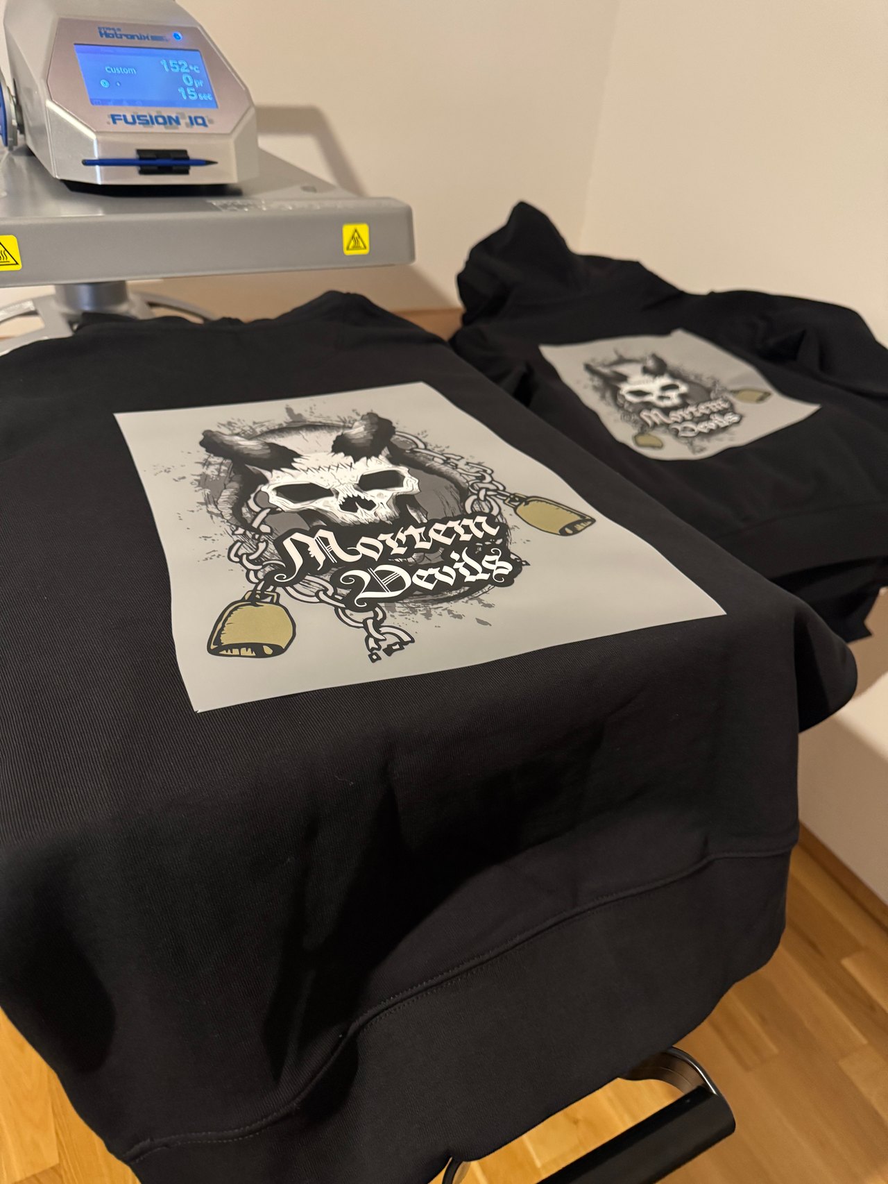 Schwarzer Hoodie mit Totenkopf-Logo Mortem Devils unter der Transferpresse