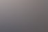 Junge Frau mit langen braunen Haaren und blauem Pullover lächelt am Schreibtisch neben einem Monitor mit "terra"-Logo.