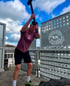 Mann in Sportkleidung schlägt mit einem Hammer auf einen Reifen.