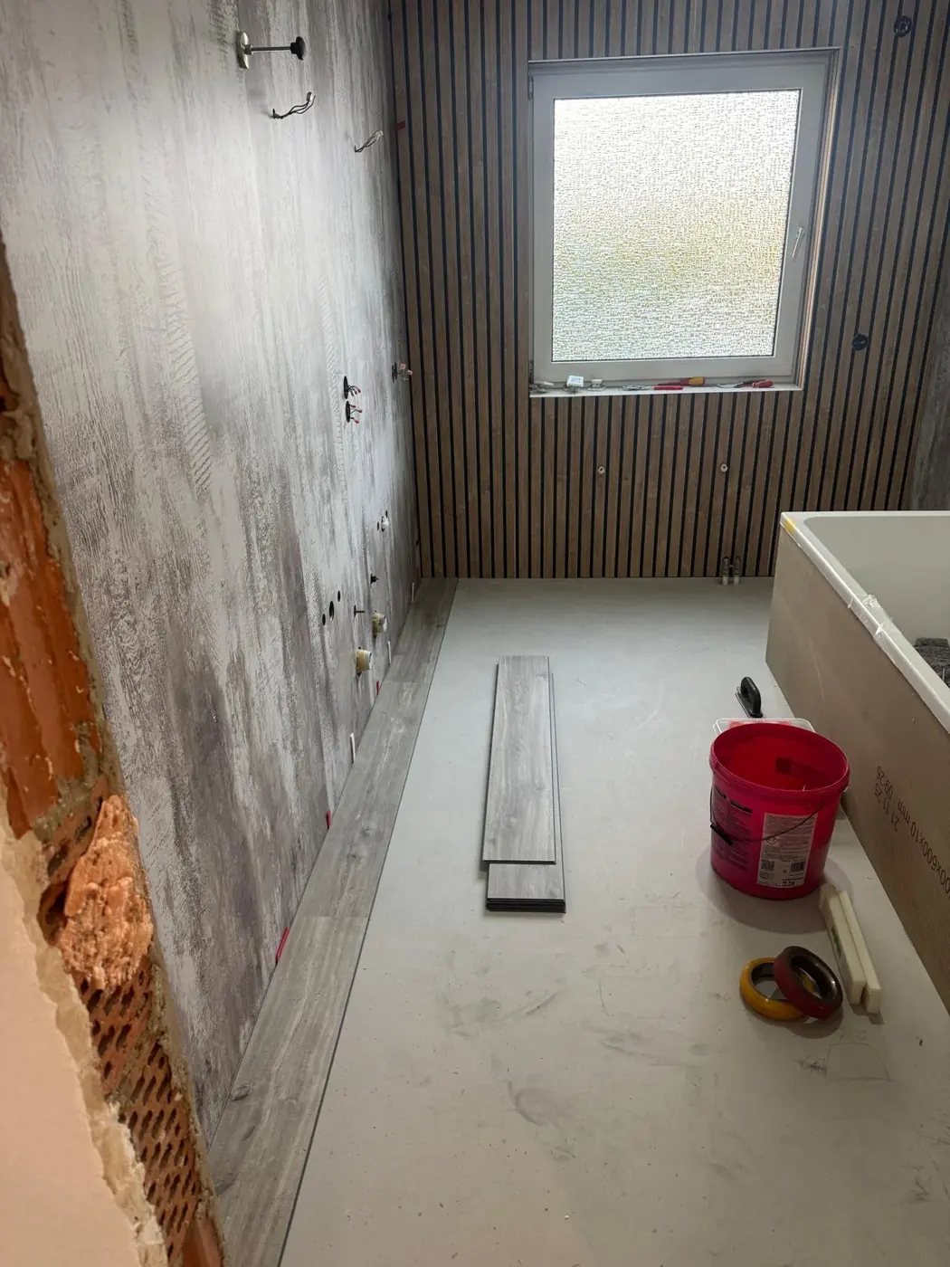 Bad mit Holzlamellenwand, Vinylboden wird verlegt