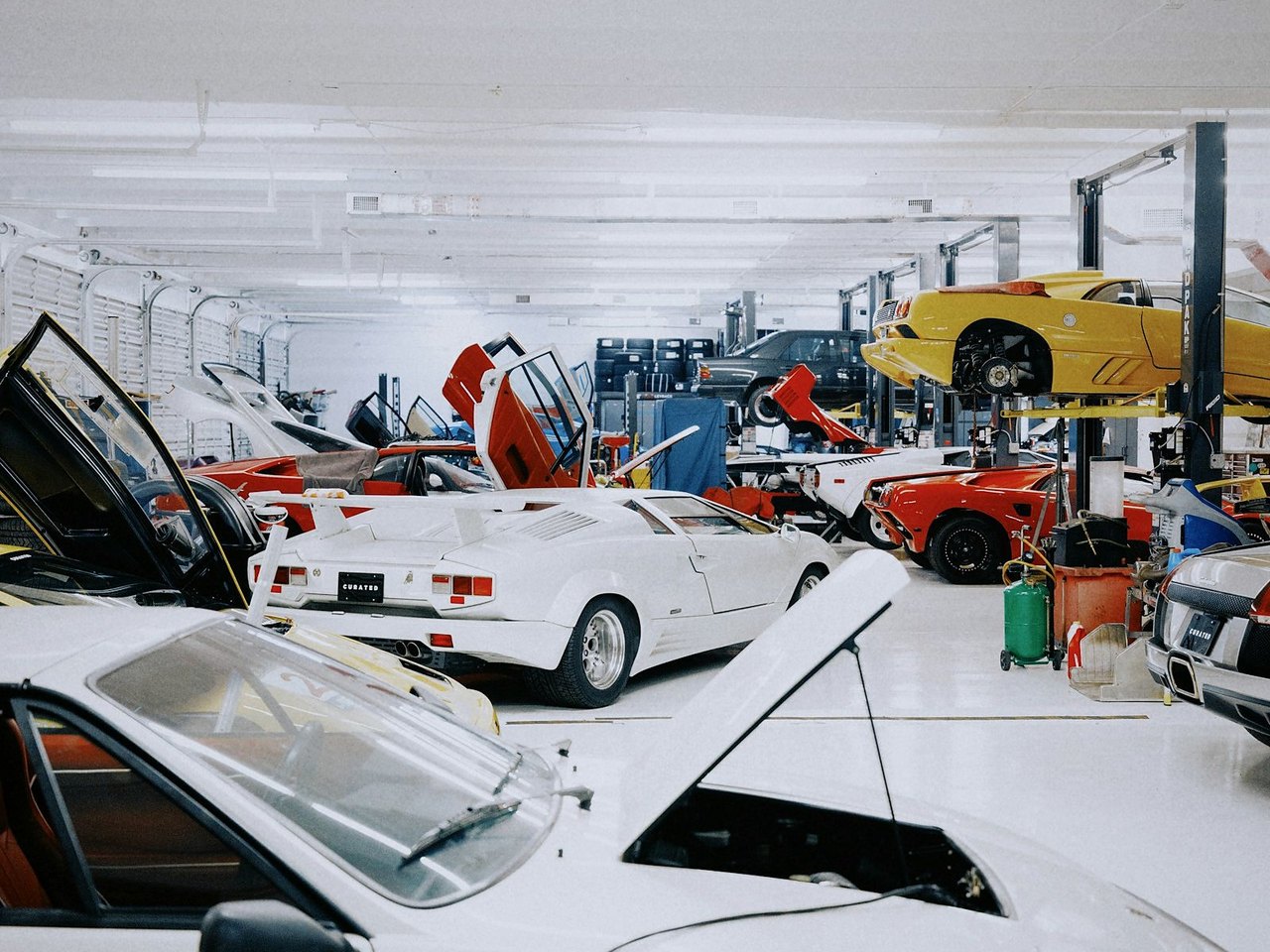 Moderne Werkstatt mit Fahrzeugen auf Hebebühnen