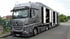 Autotransporter für einen geschlossenen Fahrzeugtransport mit geöffneten Seitenwänden.