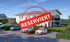 Mehrfamilienhaus mit Parkplätzen und Spielplatz, roter Stempel "RESERVIERT"
