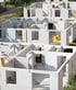 White aerated concrete block walls form the shell of multiple houses at a residential construction site.
