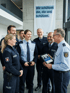 Polizeivollzugsbeamtin im Dienst neben einem Streifenwagen