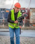 Tommy Döscher mit Kamera auf einem Gimbal, Schutzhelm und Warnweste vor Hafencontainern.