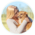 Lisa-Maria küsst einen braunen Hund auf die Stirn, umgeben von einem grünen Kreis.