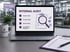Laptop displaying "INTERNAL AUDIT" with checklist, magnifying glass, and four audit types. FastLane Quality mug.