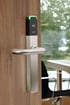 Elektronisches Salto Türschloss mit RFID-Leser, grün leuchtender LED-Anzeige und Edelstahl-Drücker an einer Holztür.