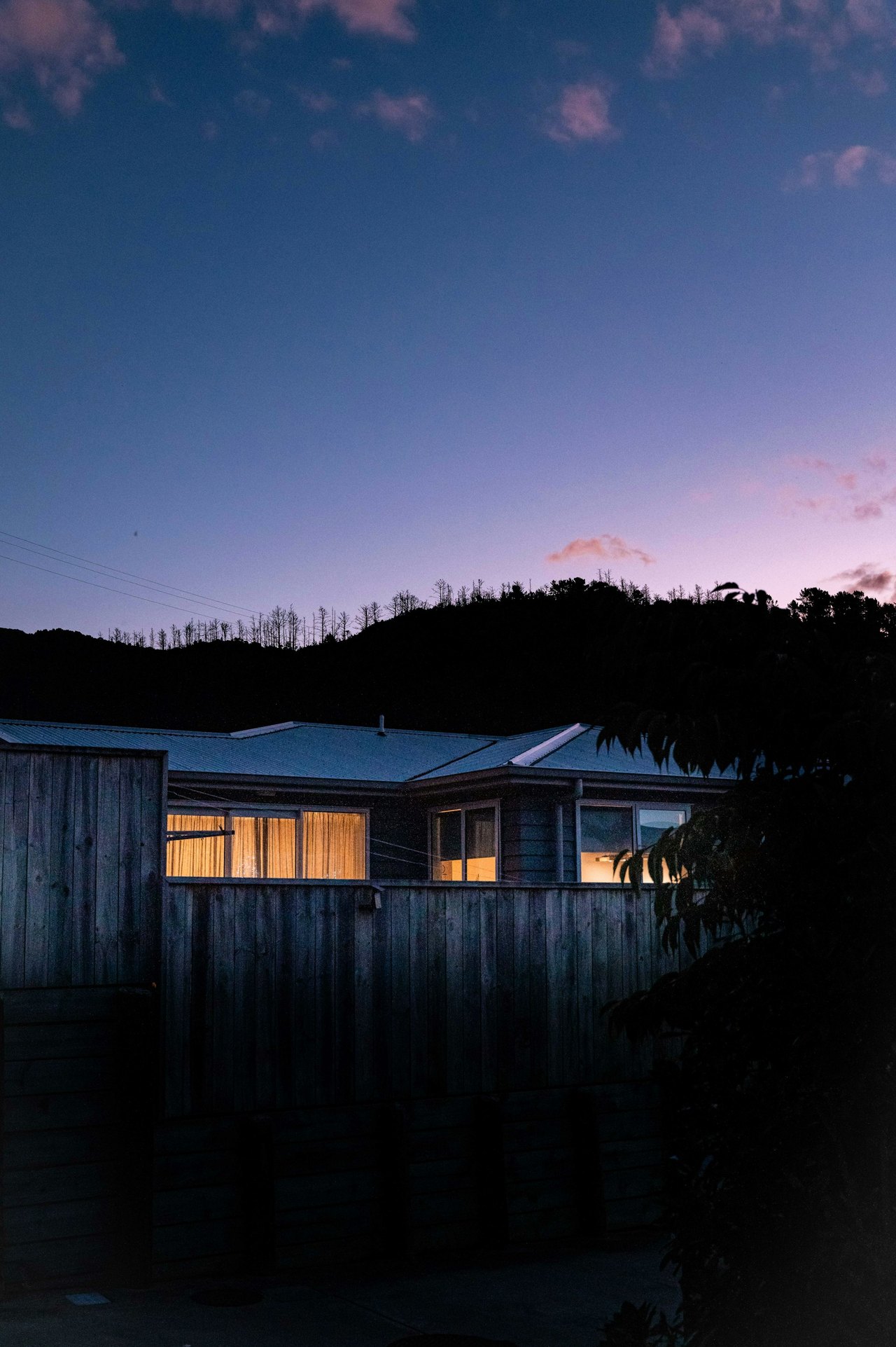 A Fishers area home with illuminated windows at dusk