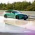 Ein grüner BMW M3 Touring fährt bei hoher Geschwindigkeit über eine nasse Rennstrecke mit Berger-Schriftzug.