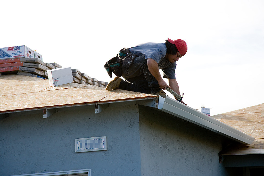 Installer fitting new guttering along the eave of a house