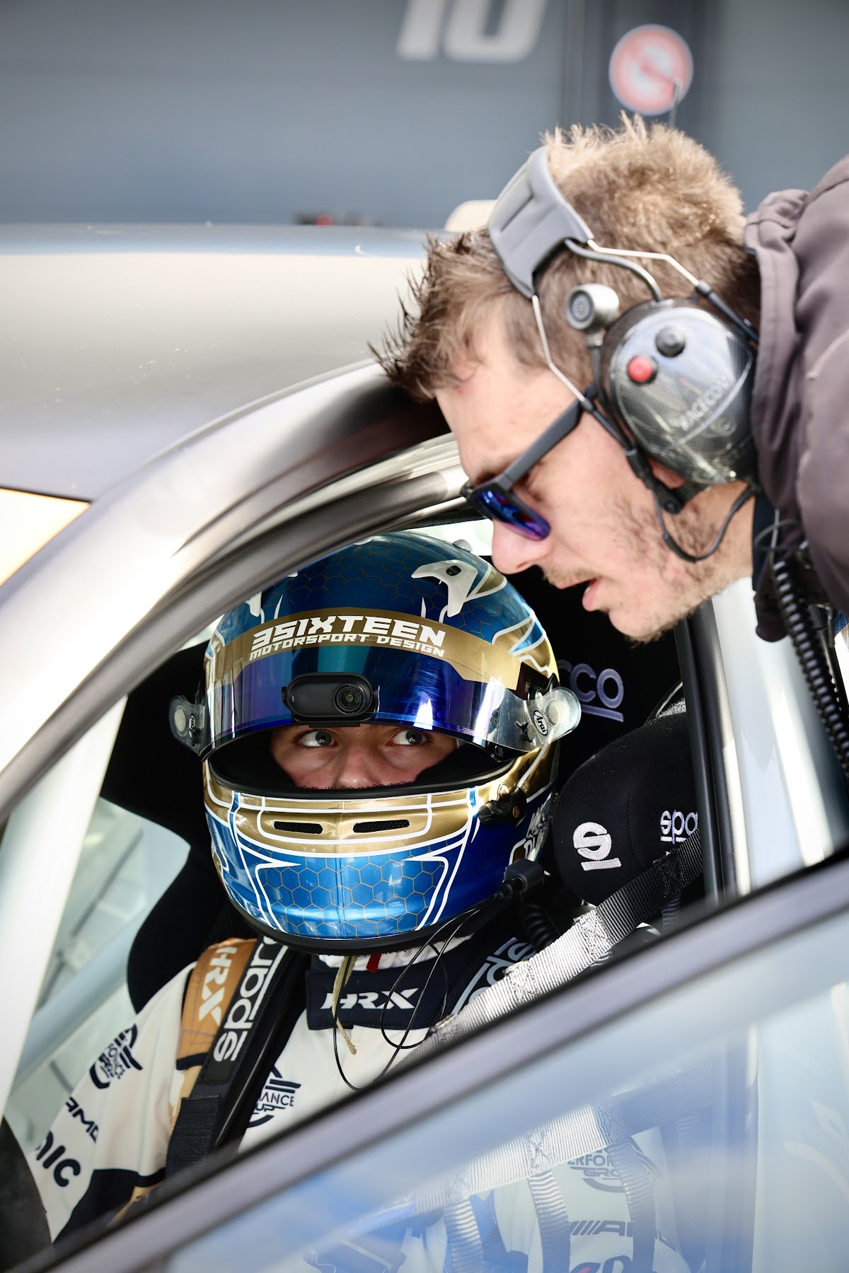 Marlon mit Helm im Cockpit, ein Mechaniker schaut zu