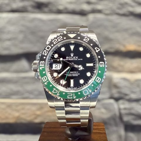 Rolex GMT-Master II Armbanduhr mit schwarzem Zifferblatt, grünem und schwarzem Lünettenrand und Datumsanzeige.