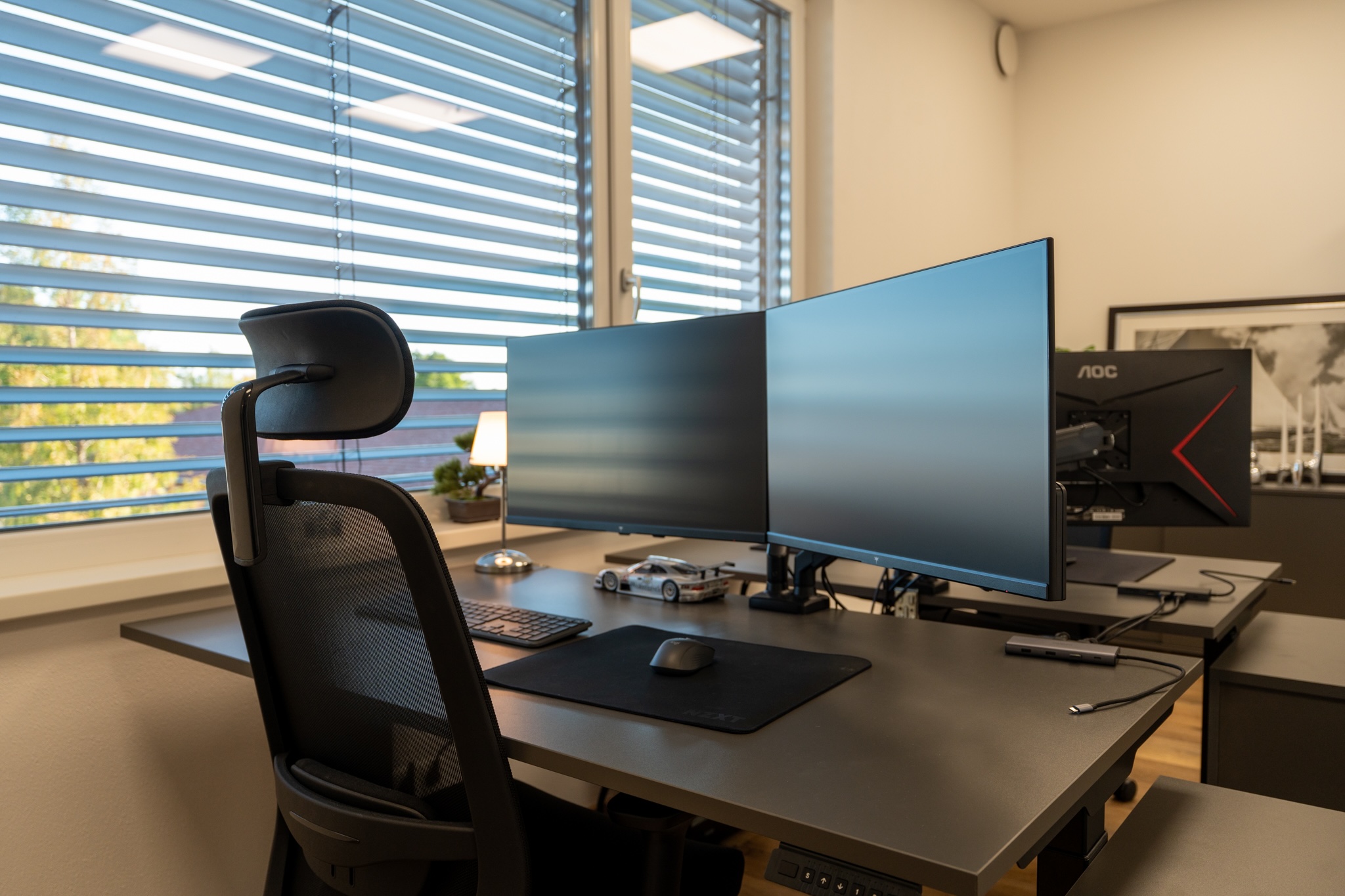 Arbeitsplatz mit höhenverstellbarem Schreibtisch und ergonomischem Bürostuhl