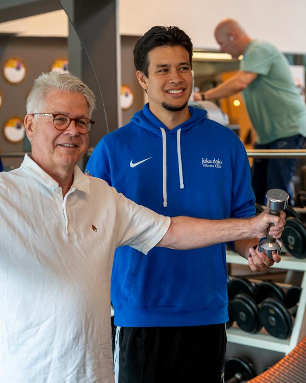 Trainer begleitet ein Mitglied an einem Trainingsgerät im juka dojo