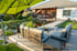 Moderner Garten mit Schwimmteich, Holzterrasse, Lounge-Möbeln und einem Einfamilienhaus im Hintergrund.