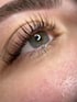 Ein geschlossenes Auge mit langen, dunklen Wimpern und graublauer Iris.
