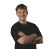 Lächelnder junger Mann mit kurzen braunen Haaren, schwarzem T-Shirt, Halskette und verschränkten Armen vor schwarzem Hintergrund.