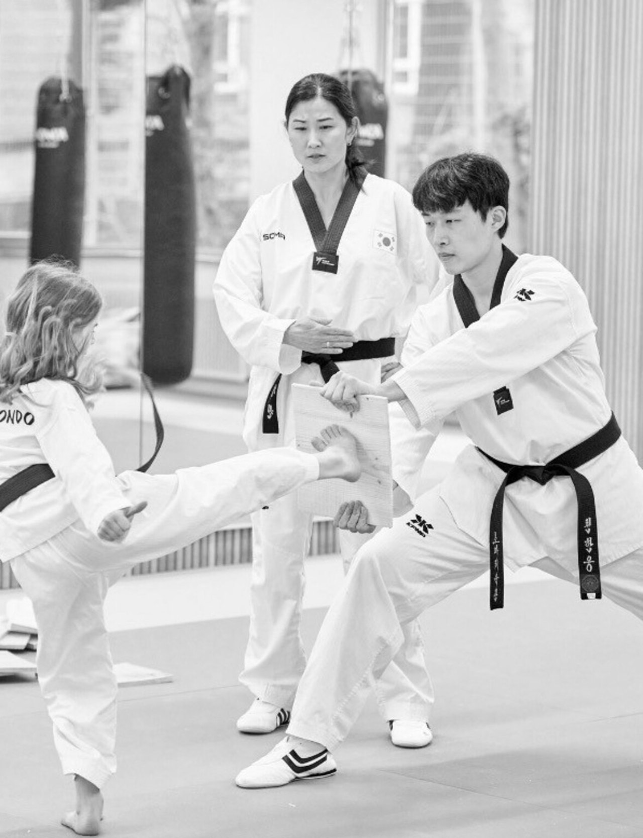 Mädchen tritt beim Bruchtest auf ein Holzbrett bei SOMA Taekwondo Bonn